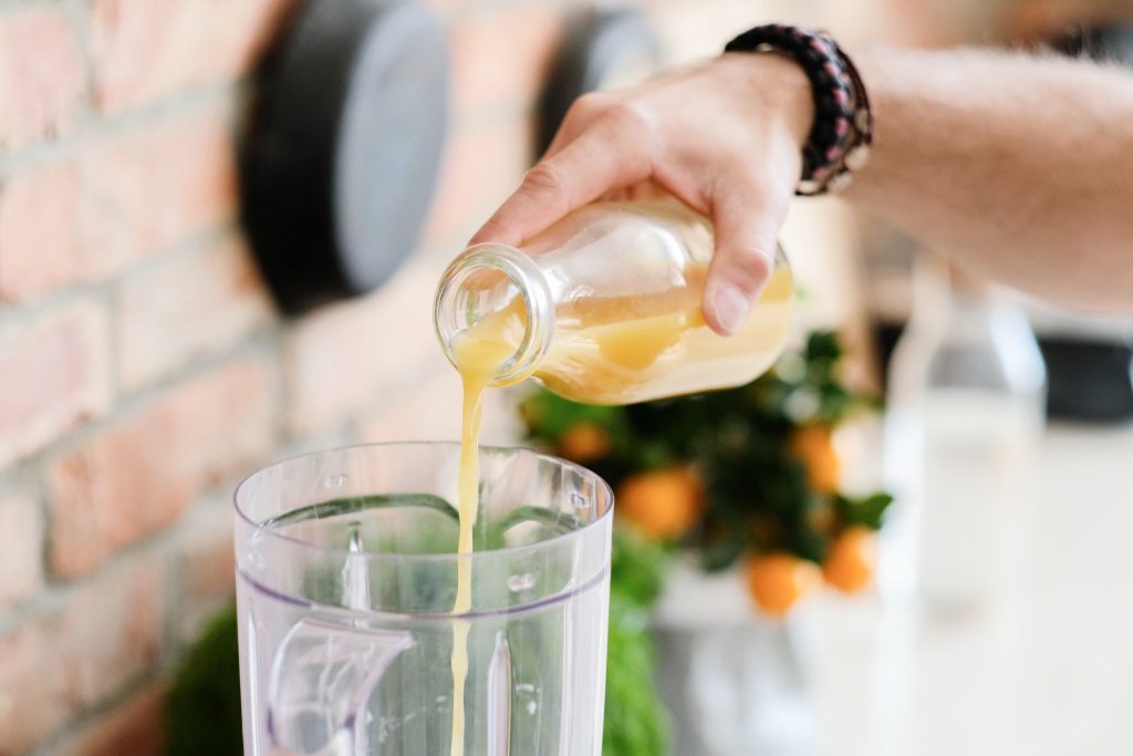Fruit concentrate being poured into a blended fruit smoothie.