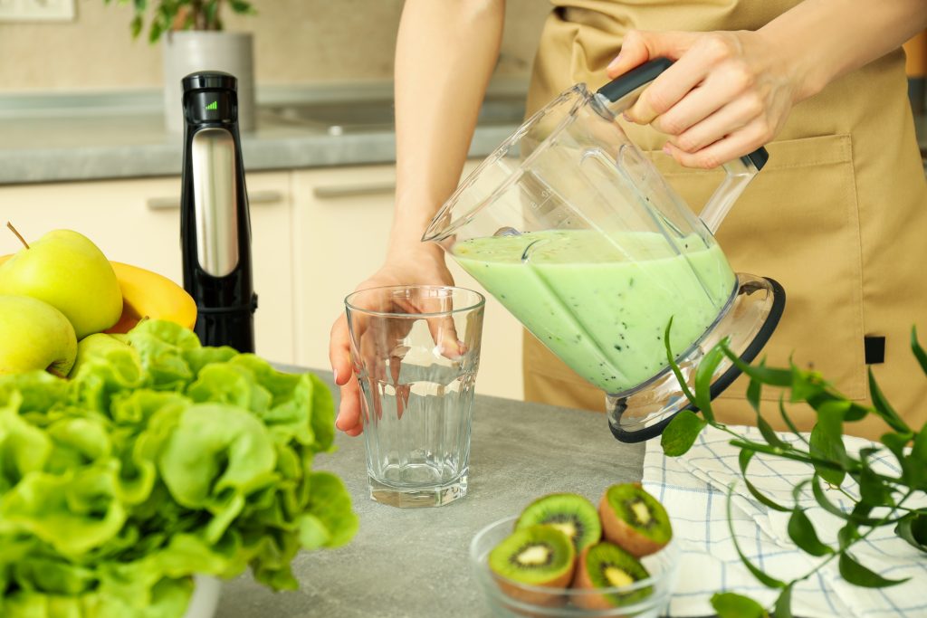 Frappe base powder blending with ice in a commercial blender.